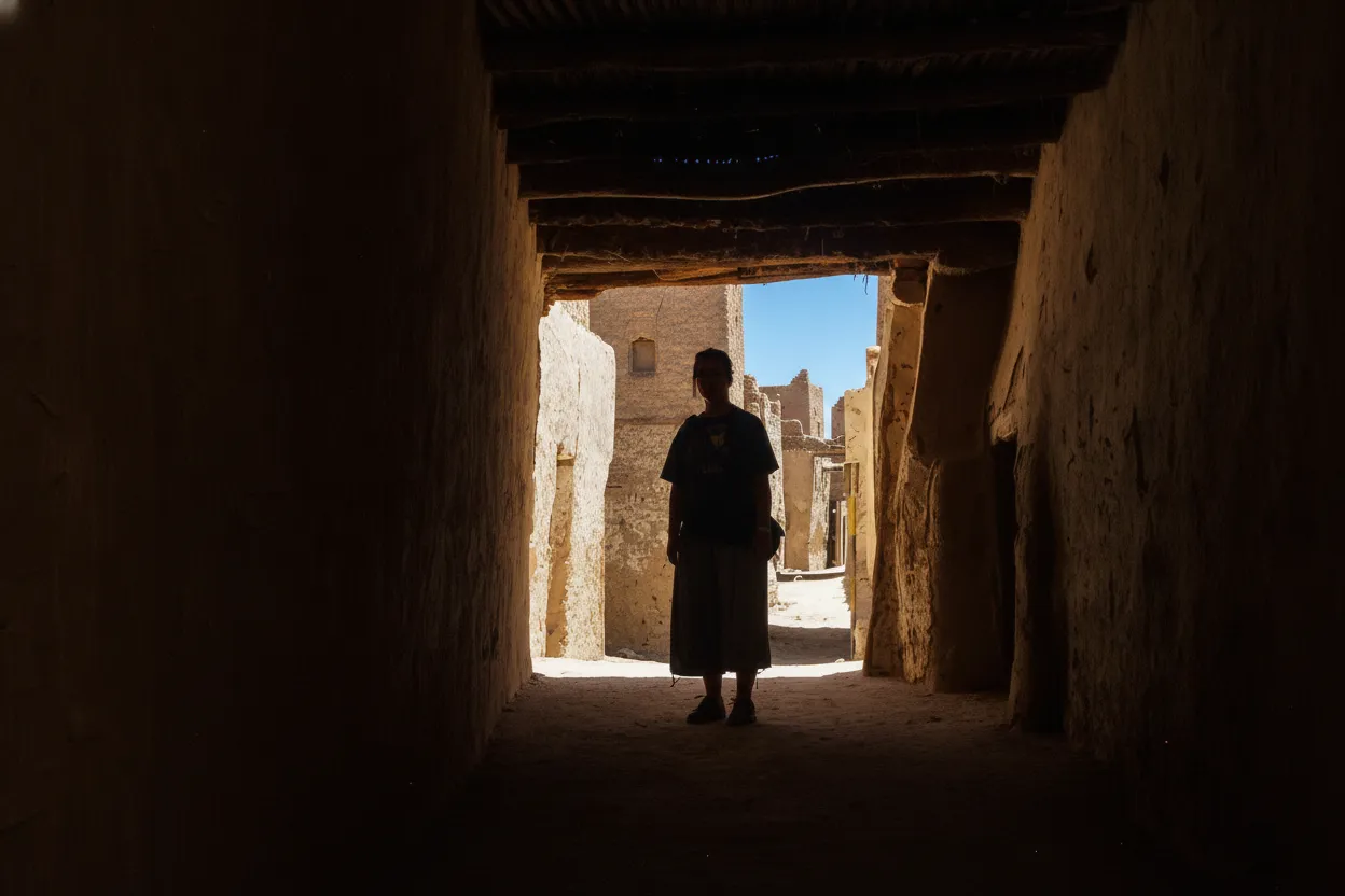 Narrow, covered alleyway in Al-Qasr, Dakhla Oasis, with mud-brick walls and palm wood ceilings
