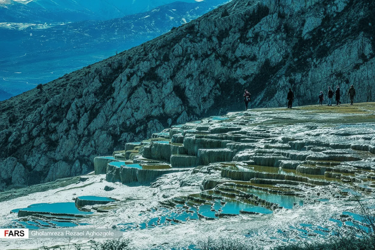 Close-up of a vibrant orange mineral pool on Badab-e Surt's travertine terraces