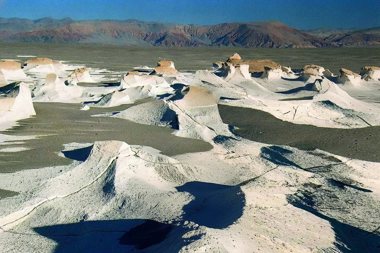 Vast field of white volcanic pumice formations under a clear blue sky, resembling a moon-like landscape in Campo de Piedra Pómez, Argentina.