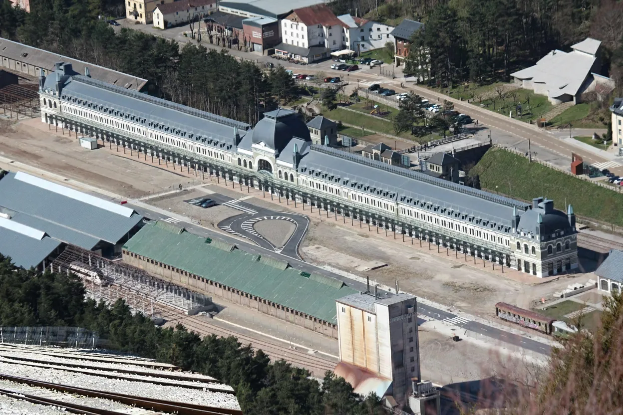 Interior view of Canfranc Station's grand hall, showing intricate architectural details and vast, empty spaces.
