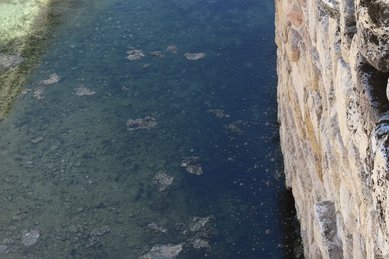 Close-up of the entrance to Pluto's Gate, showing the small fissure and ancient stone work