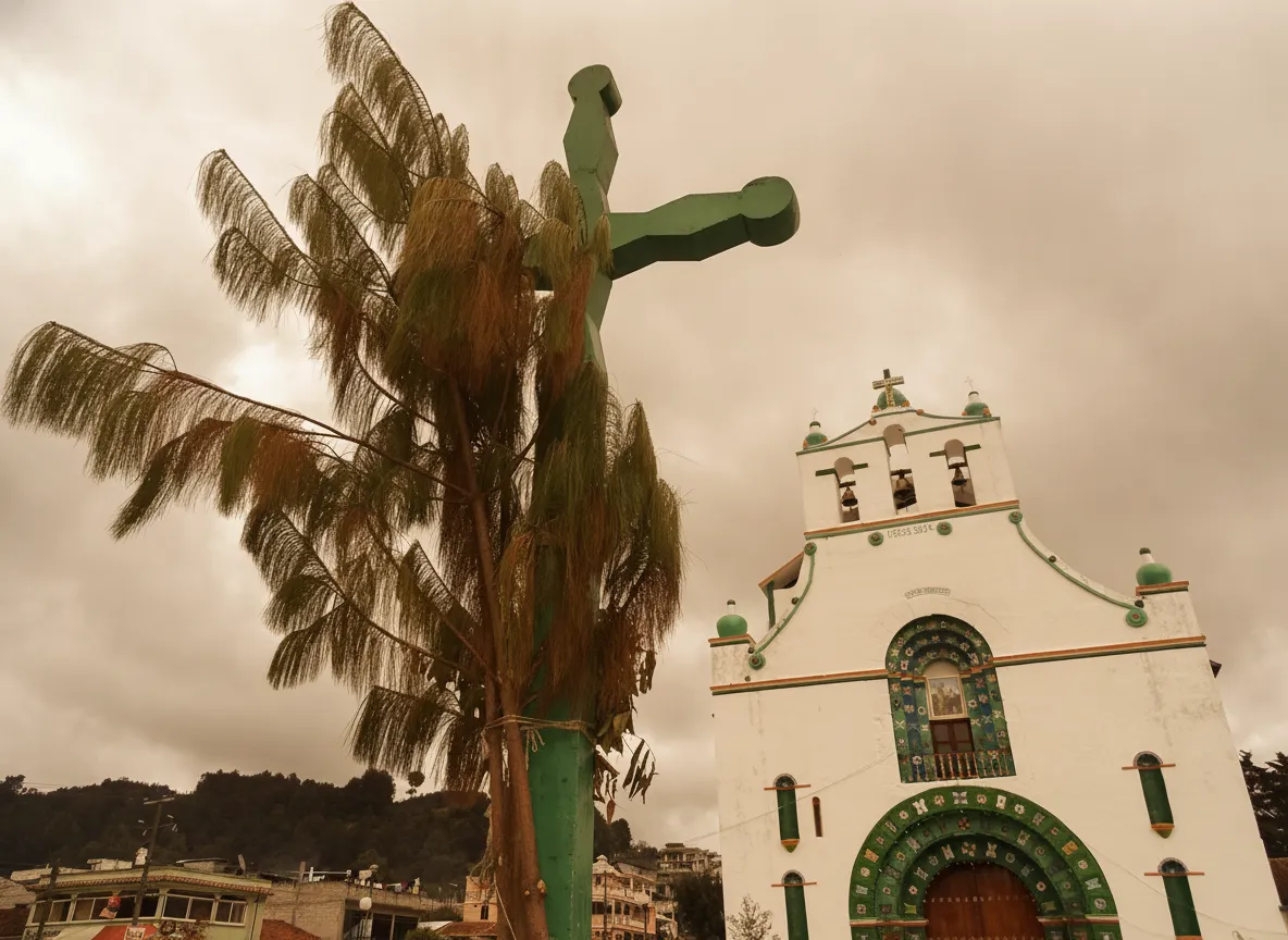 Interior of San Juan Chamula church with thousands of flickering candles on a pine-needle covered floor, families kneeling in prayer.
