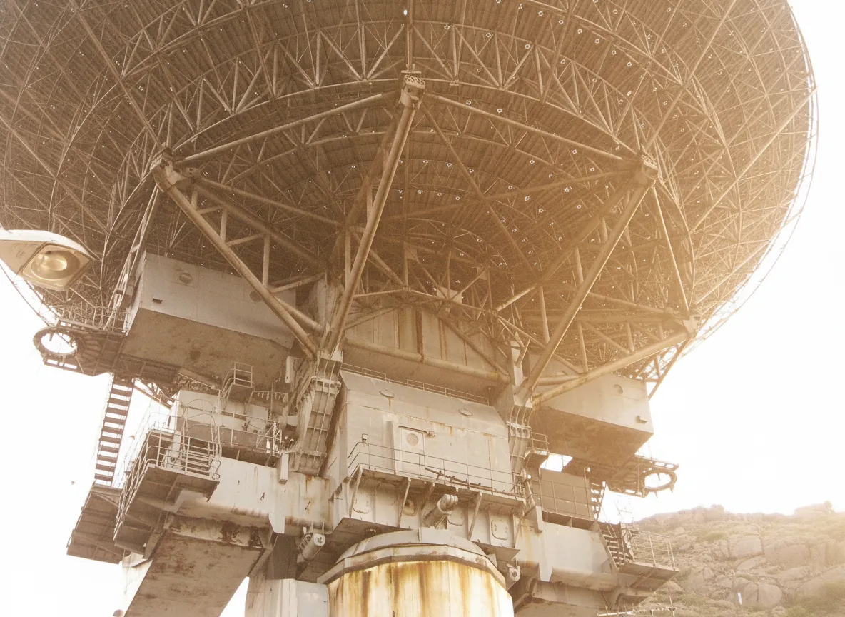 A close-up view of the rusted metal panels and support structure of the RT-16 radio telescope, showing intricate details and signs of age.