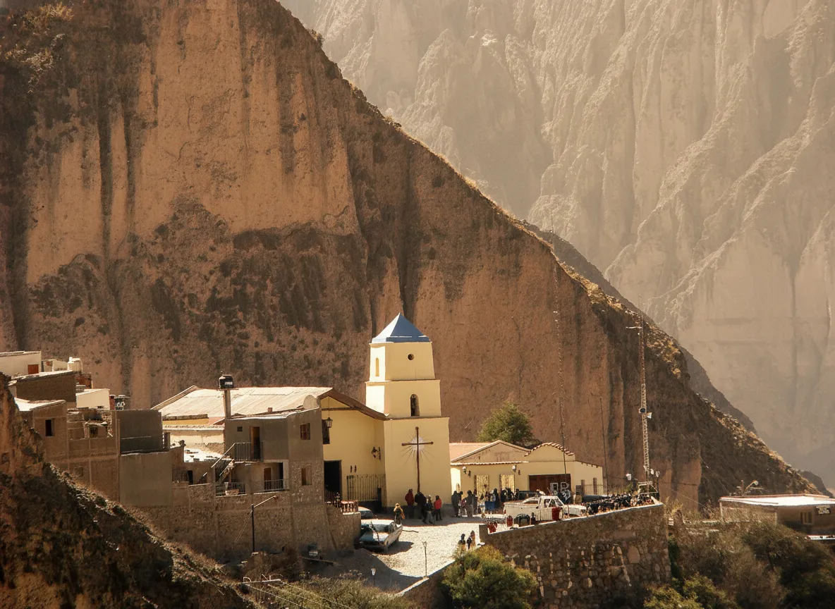 Panoramic view of Iruya village nestled in the multi-colored Andes mountains, with adobe houses blending into the landscape.