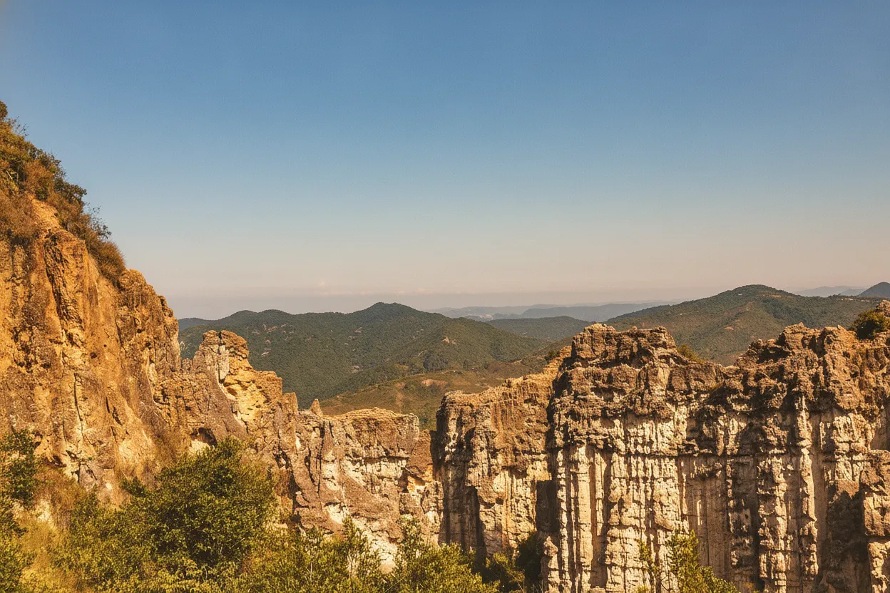 Towering red rock formations in Los Estoraques under a blue sky, with sparse green vegetation