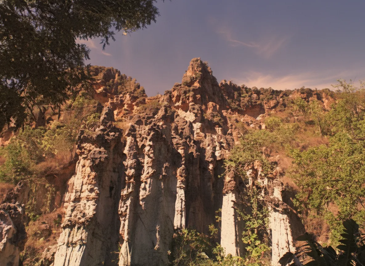 A person hiking through a narrow canyon formed by red rock pillars in Los Estoraques