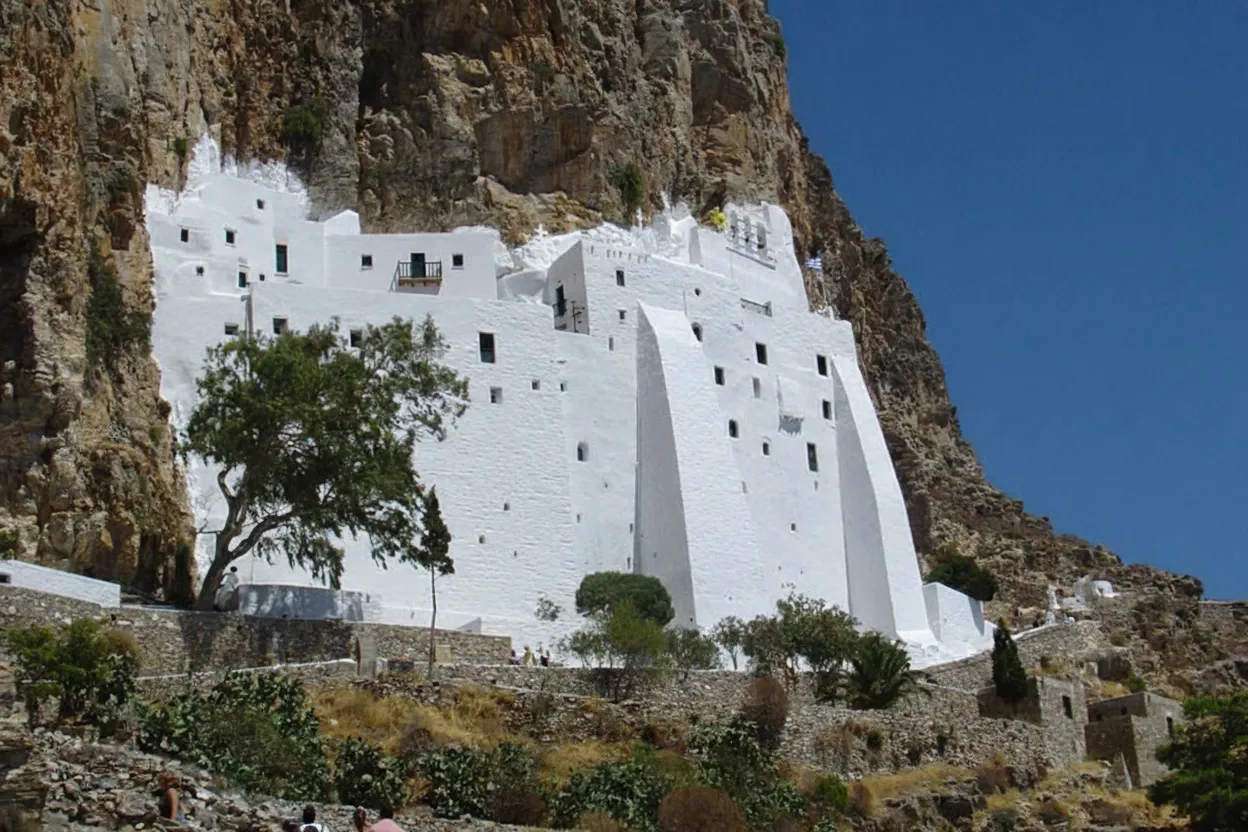 The Monastery of Panagia Hozoviotissa clinging to a red cliff face above the blue Aegean Sea, Amorgos.