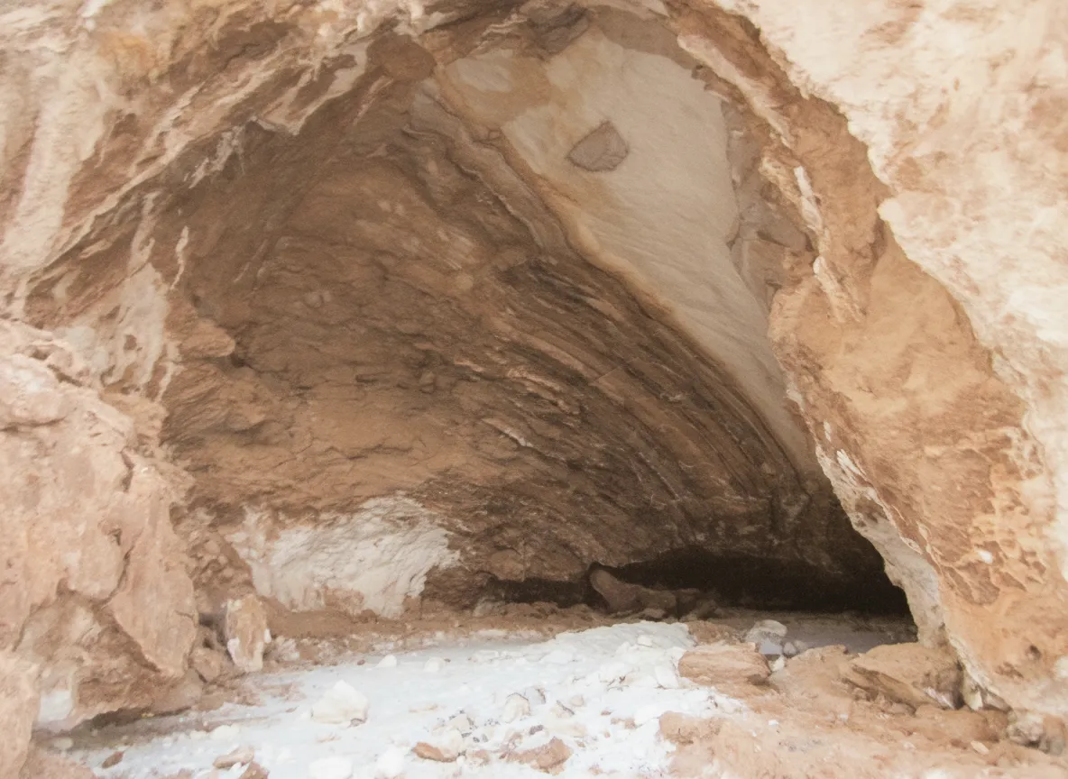 Inside Namakdan Salt Cave, showing intricate salt stalactites and shimmering walls illuminated by artificial light.