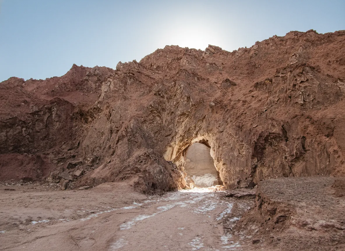 A wide shot inside the Namakdan Salt Cave, showcasing vast chambers with glowing salt formations and a narrow path for visitors.