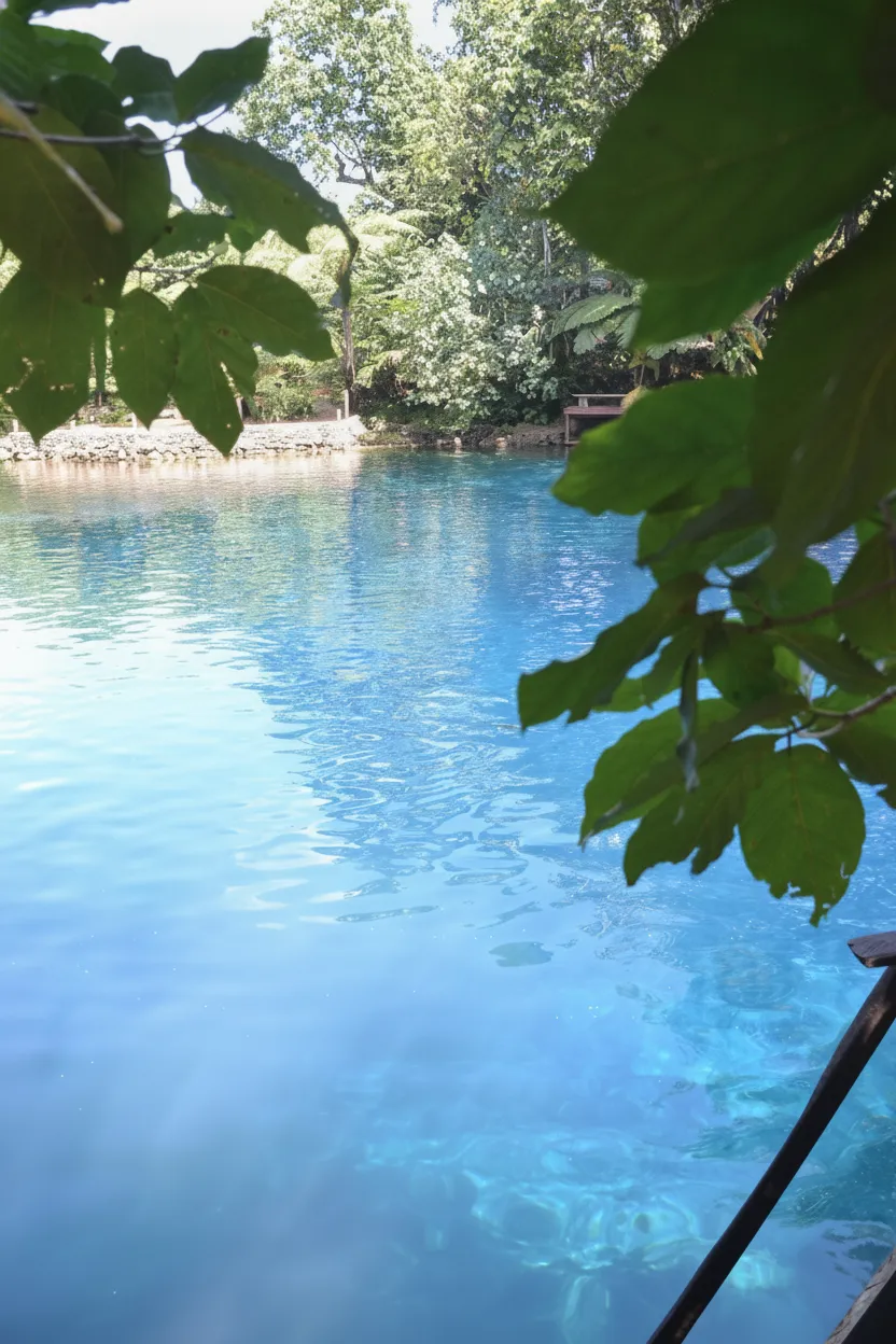 Aerial view of the Nanda Blue Hole in Vanuatu, showing its vibrant blue water surrounded by lush green jungle.