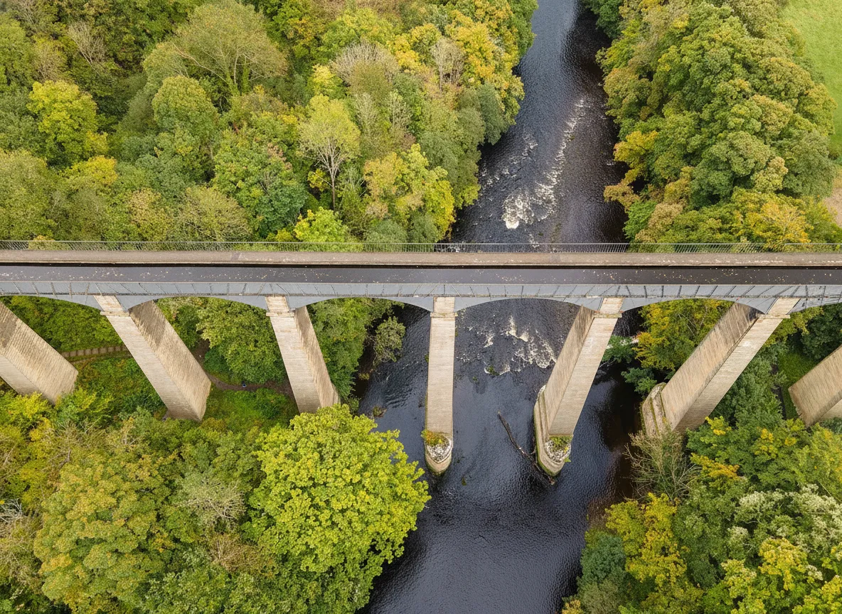 A narrowboat crossing the Pontcysyllte Aqueduct high above a valley, with green hills in the background.