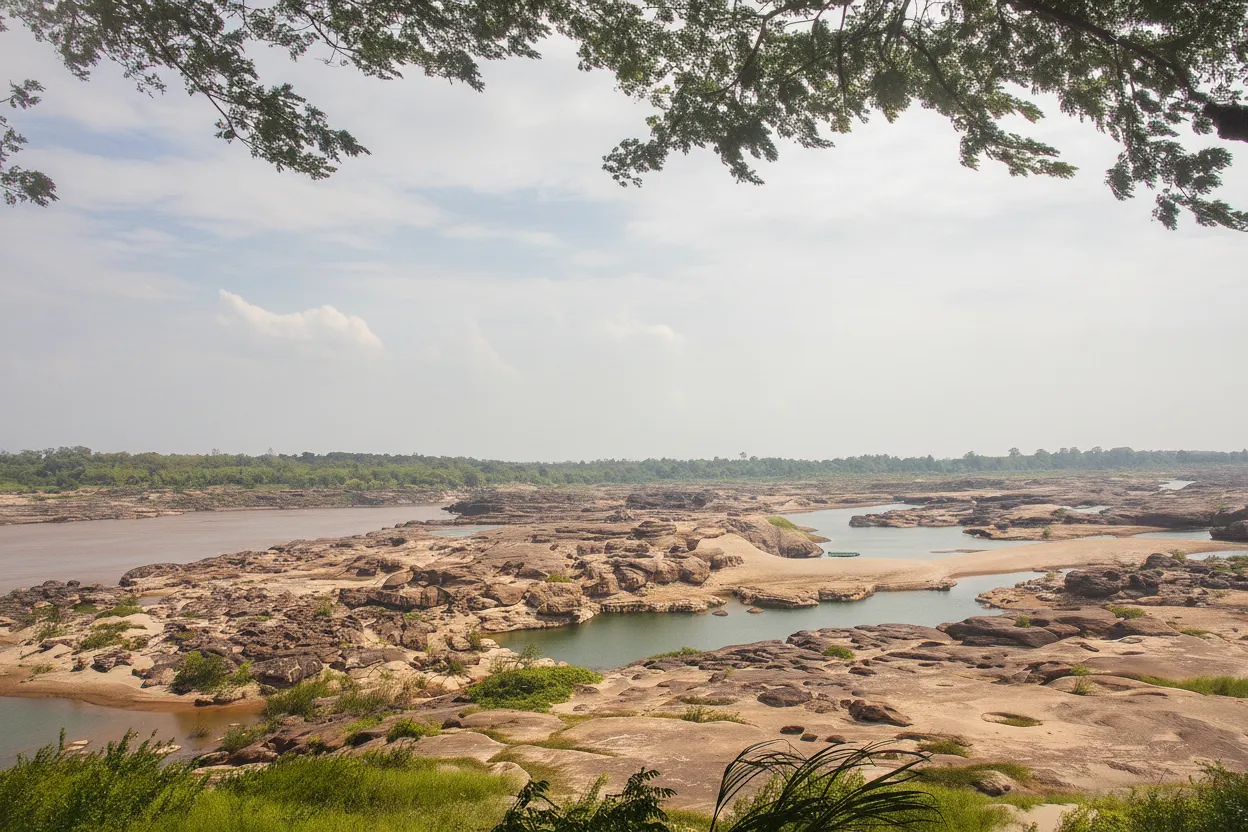 Panoramic view of Sam Phan Bok's Martian-like rock formations and numerous potholes under a clear sky in Ubon Ratchathani, Thailand.