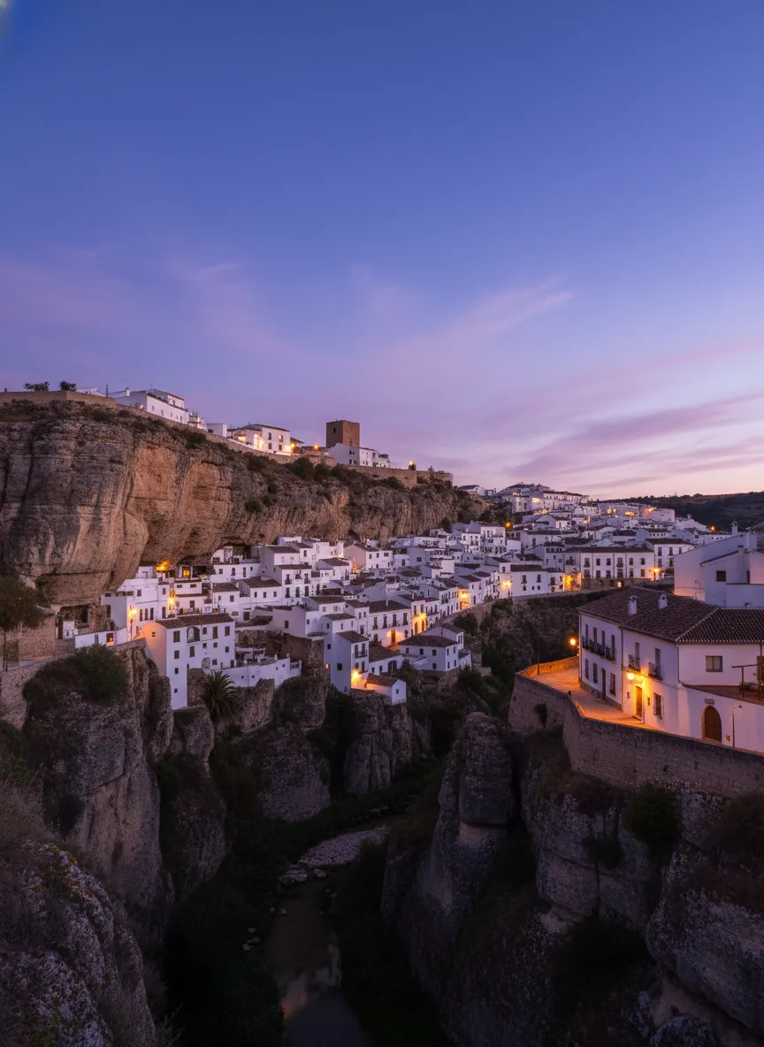 The narrow, winding streets of Setenil de las Bodegas, with whitewashed houses and glimpses of the rock formations overhead.
