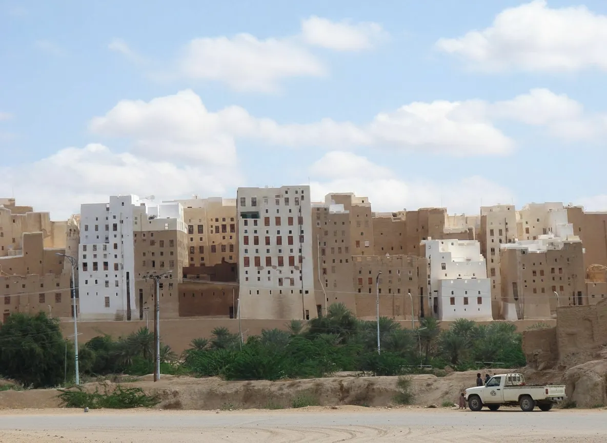 Panoramic view of Shibam, Yemen, showing its dense cluster of towering mud-brick skyscrapers rising from the desert landscape.