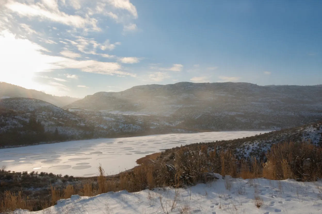 Roadside viewpoint of Spotted Lake with informative signage about its history and importance.