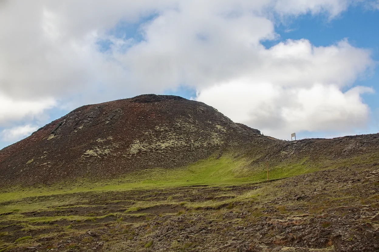 Inside the Thrihnukagigur volcano, showing the vastness of the magma chamber with illuminated red, yellow, and purple rock formations