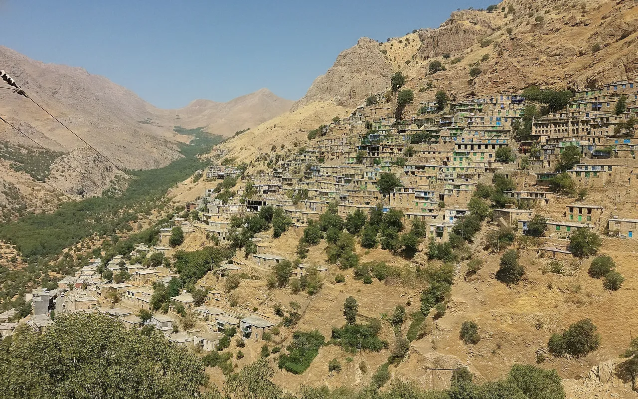 Terraced homes of Uraman Takht cascading down the steep mountainside, with roofs forming courtyards.